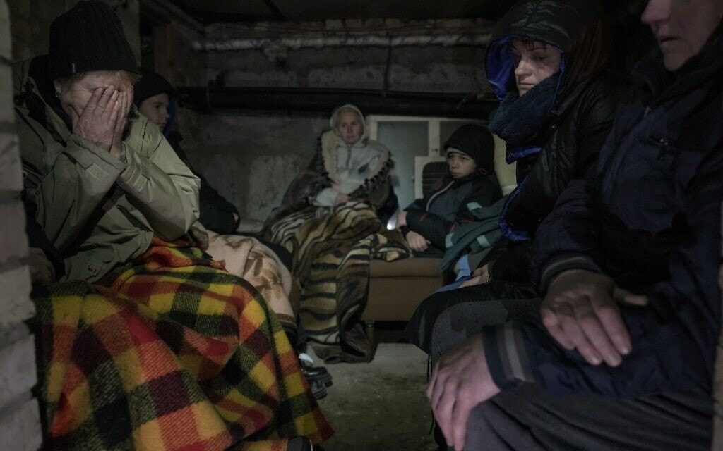 אוקראינים תופסים מכסה במרתף ביישוב ליד קייב בזמן מתקפה אווירית, 2 במרץ 2022 (צילום: AP Photo/Vadim Ghirda)