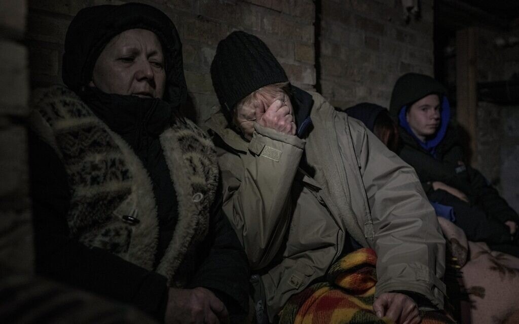 אוקראינים תופסים מכסה במרתף ביישוב ליד קייב בזמן תקיפות אוויריות רוסיות, 2 במרץ 2022 (צילום: AP Photo/Vadim Ghirda)