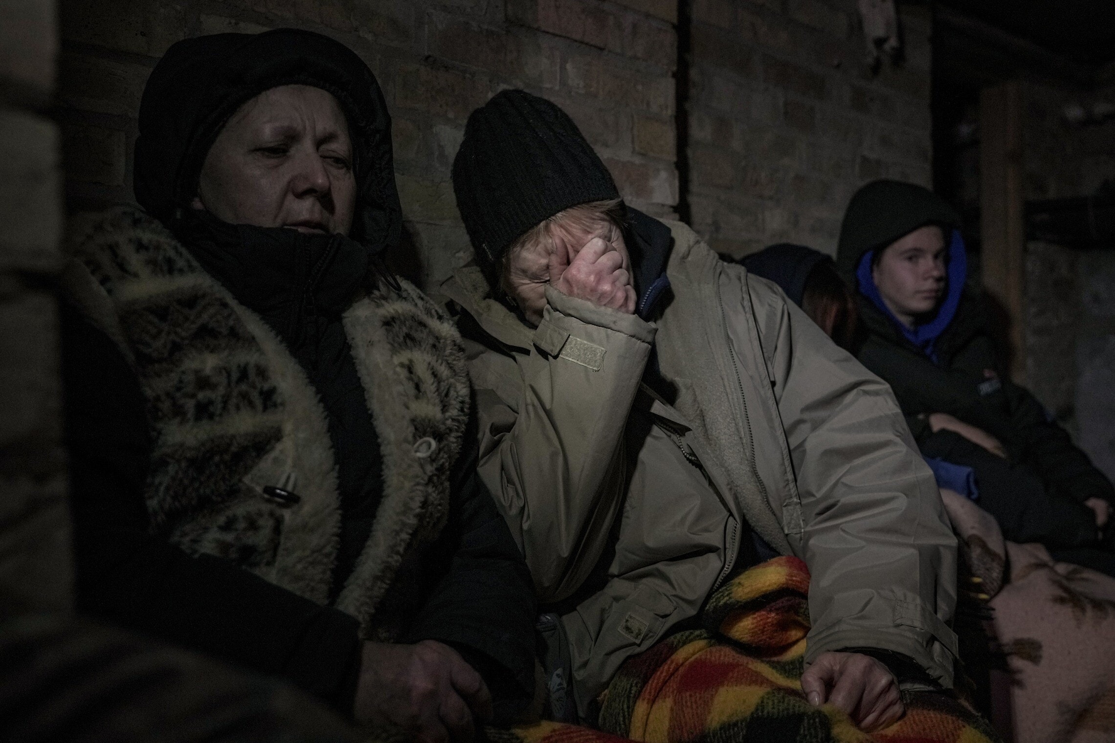 אוקראינים תופסים מכסה במרתף ביישוב ליד קייב בזמן תקיפות אוויריות רוסיות, 2 במרץ 2022 (צילום: AP Photo/Vadim Ghirda)