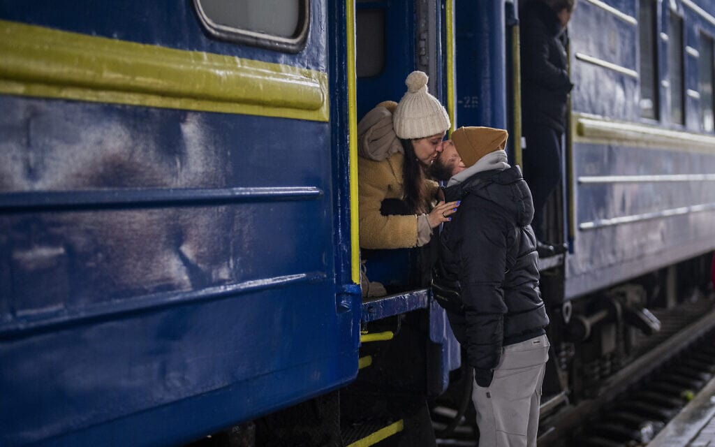 בני זוג נפרדים זה מזה בתחנת הרכבת בקייב, כשהאישה נוסעת ללביב, ובעלה נשאר בבירה, 3 במרץ 2022 (צילום: Emilio Morenatti, AP)