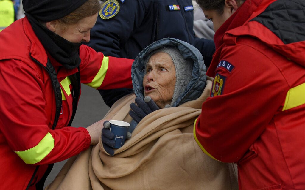 עובדי המחלקה למצבי חירום מסייעים לפליטה שנמלטה מאוקראינה בסירט שברומניה, 5 במרץ 2022 (צילום: Andreea Alexandru)
