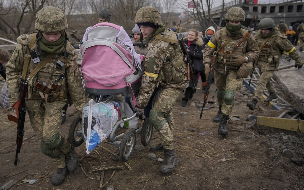 אנשי שירות אוקראיניים מסייעים לנמלטים מהעיר אירפין שבמחוז קייב, 5 במרץ 2022 (צילום: Vadim Ghirda, AP)