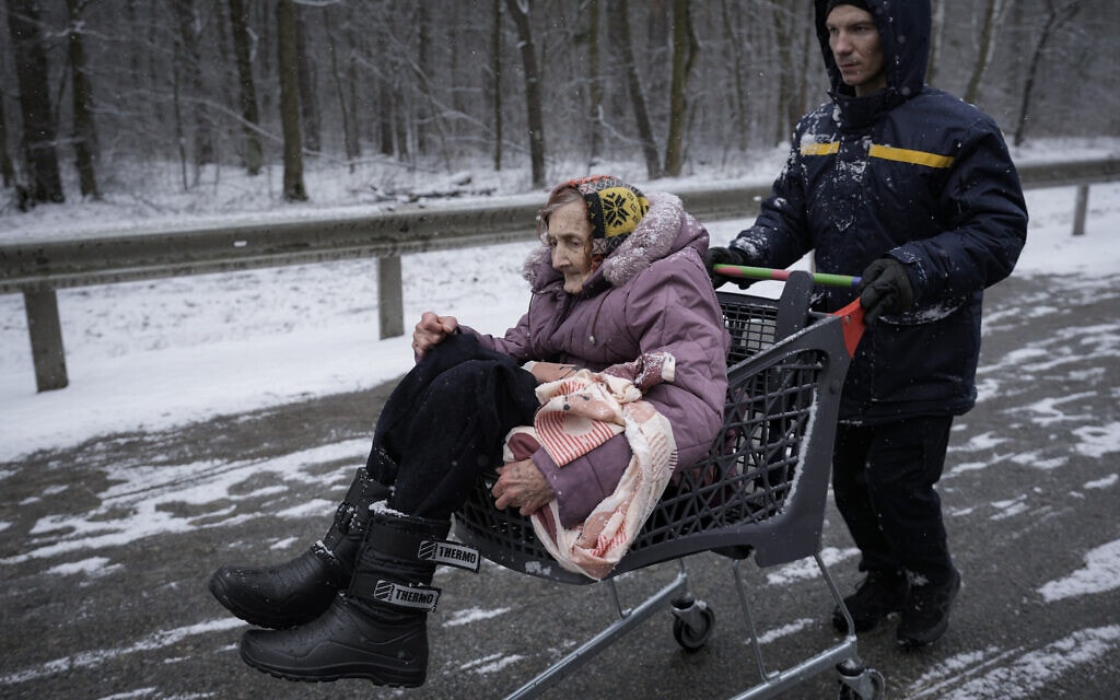 קשישה מפונה בעגלת קניות מאירפין שבפאתי קייב, 8 במרץ 2022 (צילום: Vadim Ghirda, AP)