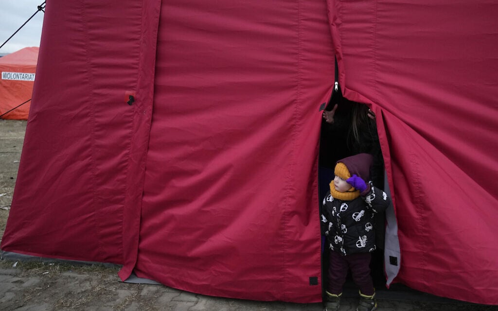 ילד שנמלט מאוקראינה מציץ מהאוהל שבו הוא נמצא במרכז סיוע בפשמישל שבפולין, 8 במרץ 2022 (צילום: Czarek Sokolowski, AP)