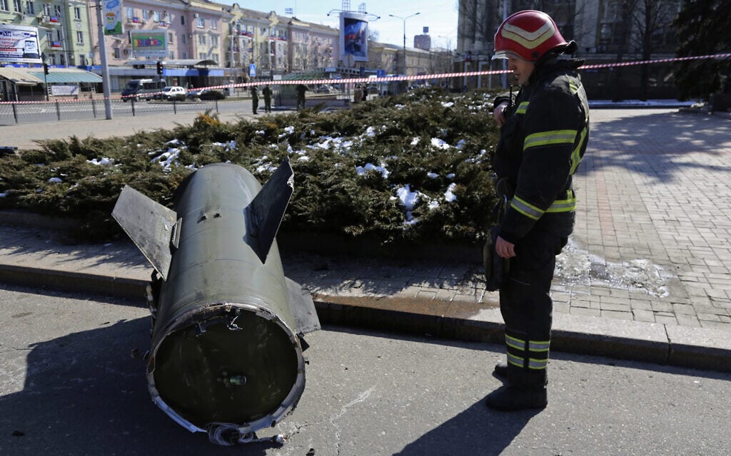 כבאי מביט על טיל שהרוסים טוענים שנורה על ידי האוקראינים לדונייצק, 14 במרץ 2022 (צילום: AP Photo/Alexei Alexandrov)