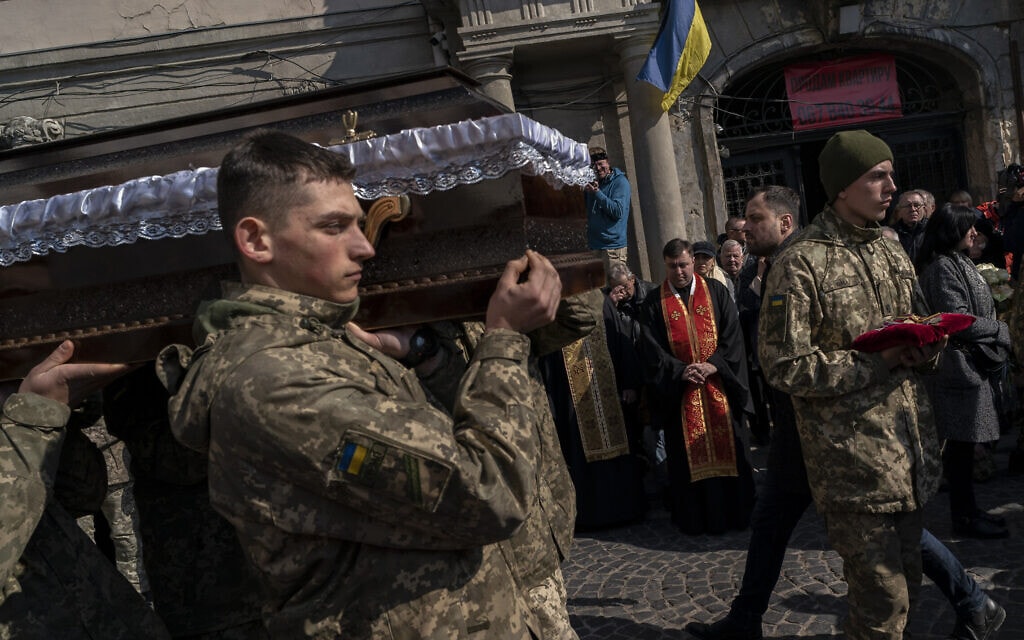 חיילים נושאים את ארונו של אחד מבין ארבעת אנשי הצבא שנהרגו בהפצצת בסיס צבאי ליד גבולה המערבי של אוקראינה, 15 במרץ 2022 (צילום: Bernat Armangue, AP)