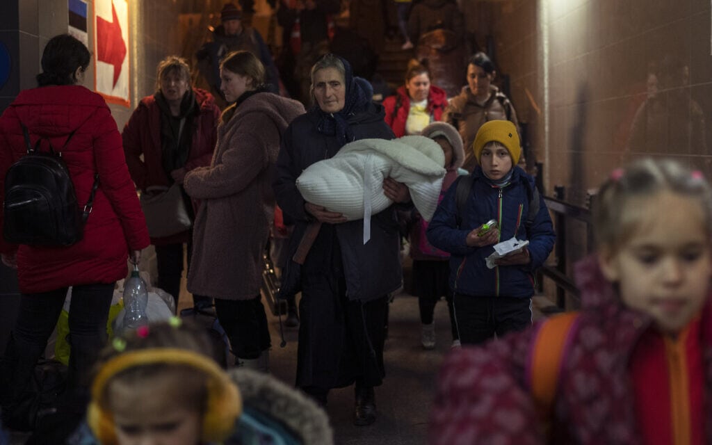 עקורים שנמלטו מאוקראינה עוזבים את תחנת הרכבת בפשמישל שבפולין, 15 במרץ 2022 (צילום: Petros Giannakouris, AP)