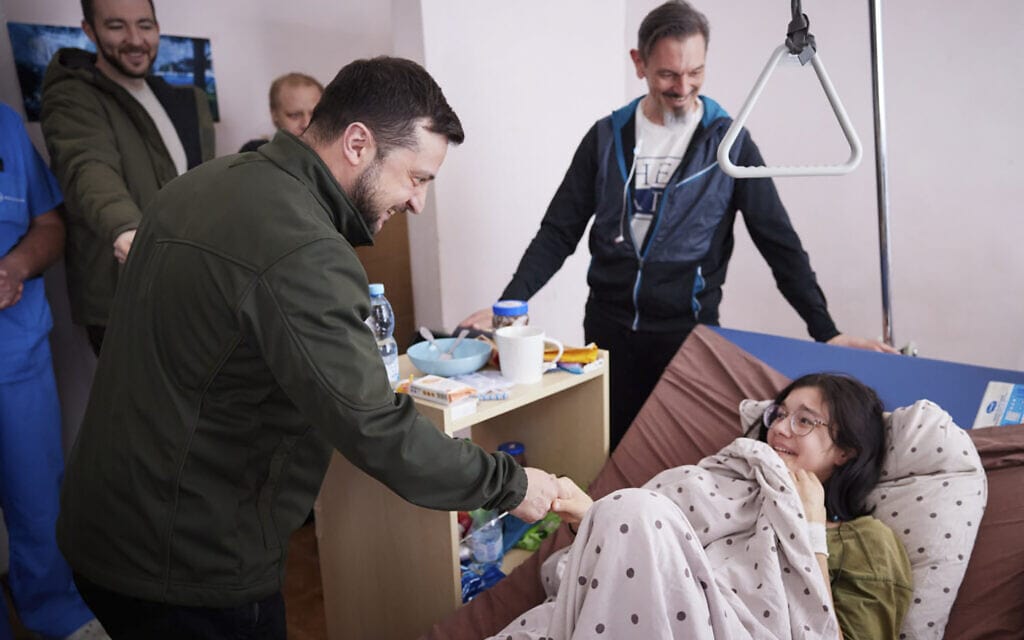 נשיא אוקראינה וולודימיר זלנסקי מבקר בבית חולים בקייב את קטרינה ולסנקו בת ה-16 שנפצעה כשגוננה על אחיה בזמן ההפגנות, 17 במרץ 2022 (צילום: Ukrainian Presidential Press Office via AP)