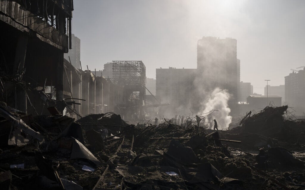 כבאים מכבים שרפה ליד מרכז קניות שנפגע בהפגזות בקייב שבאוקראינה, 21 במרץ 2022 (צילום: Felipe Dana, AP)