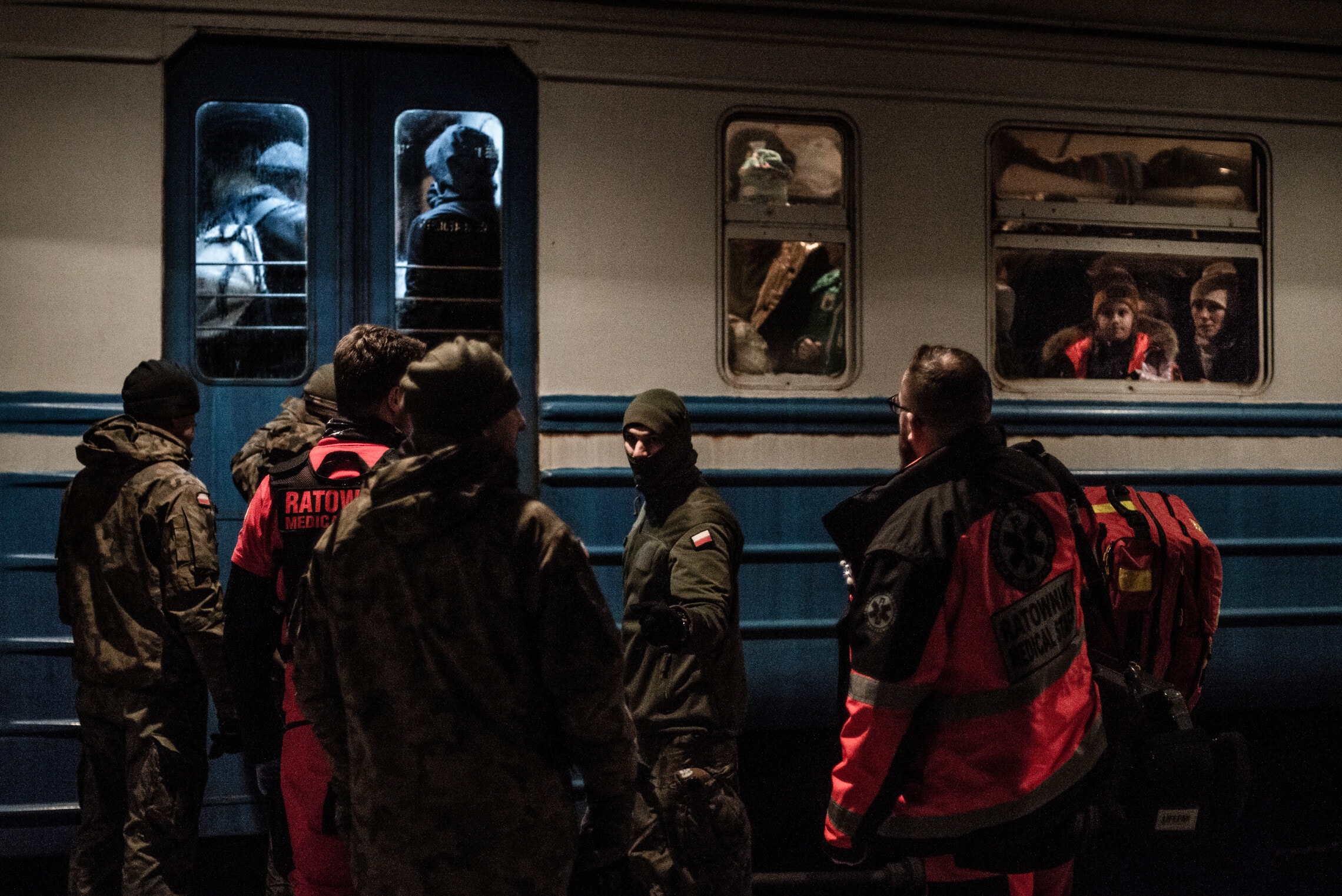צוות רפואת חירום בכניסה לקרון רכבת בתחנה פשמישל, פולין, לאחר שנקרא לטפל בפליטה בת שנתיים שאיבדה את הכרה. פברואר 2022 (צילום: גילעד שדה)