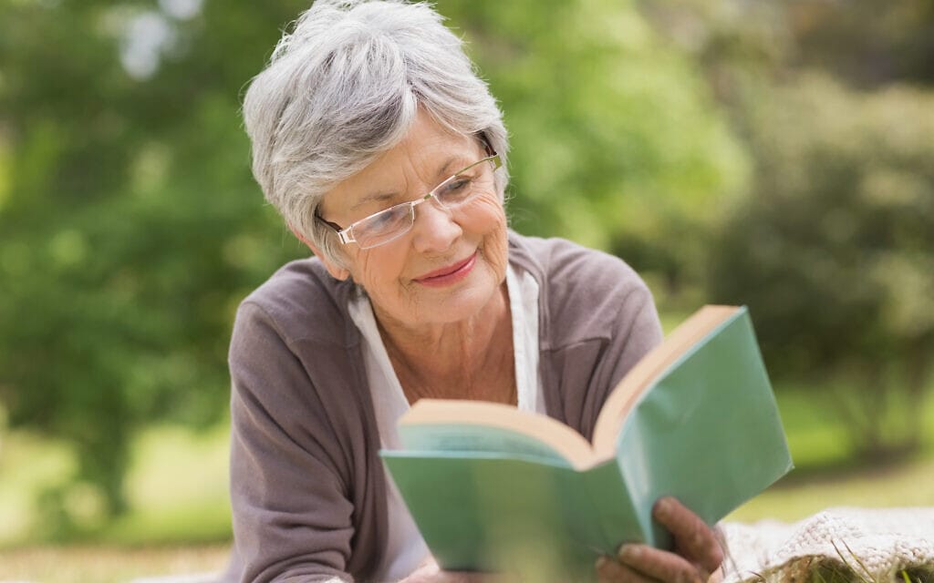 אשה מבוגרת קוראת ספר (צילום: iStock / Wavebreakmedia)