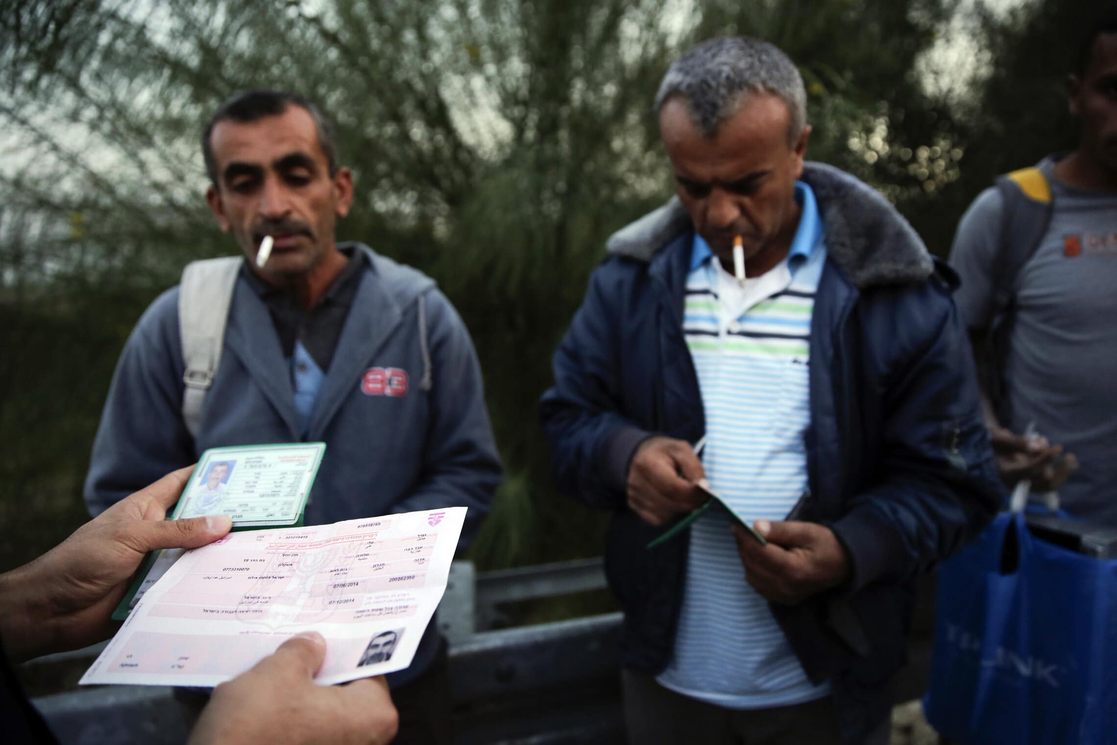 שוטר מג&quot;ב בודק את רישיונות העבודה של פלסטינים באזור אשקלון, נובמבר 2014 (צילום: AP Photo/Tsafrir Abayov)