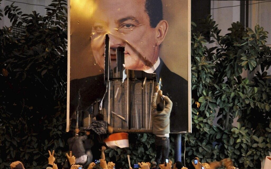 מפגינים משחיתים כרזה של נשיא מצרים חוסני מובארק באלכסנדריה, מצרים,25 בינואר 2011 (צילום: AP Photo)