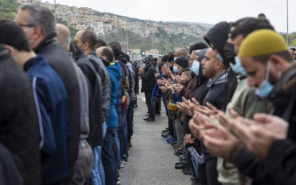 תושבי אום אל-פחם מתפללים במהלך הפגנה נגד העדר האכיפה המשטרתית בטיפול בפשיעה בחברה הערבית, 12 במרץ 2021 (צילום: AP Photo/Ariel Schalit)