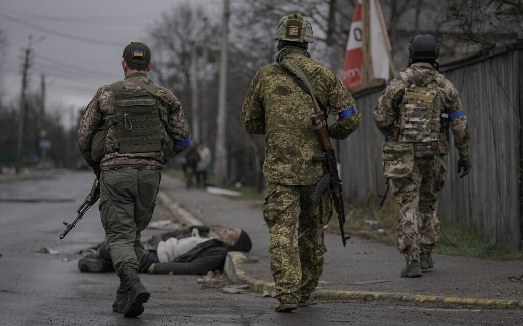 חיילים אוקראינים צועדים ברחובות בוצ&#039;ה, שם מוטלות גופות אוקראינים שנרצחו על ידי הרוסים, 3 באפריל 2022 (צילום: AP Photo/Vadim Ghirda)