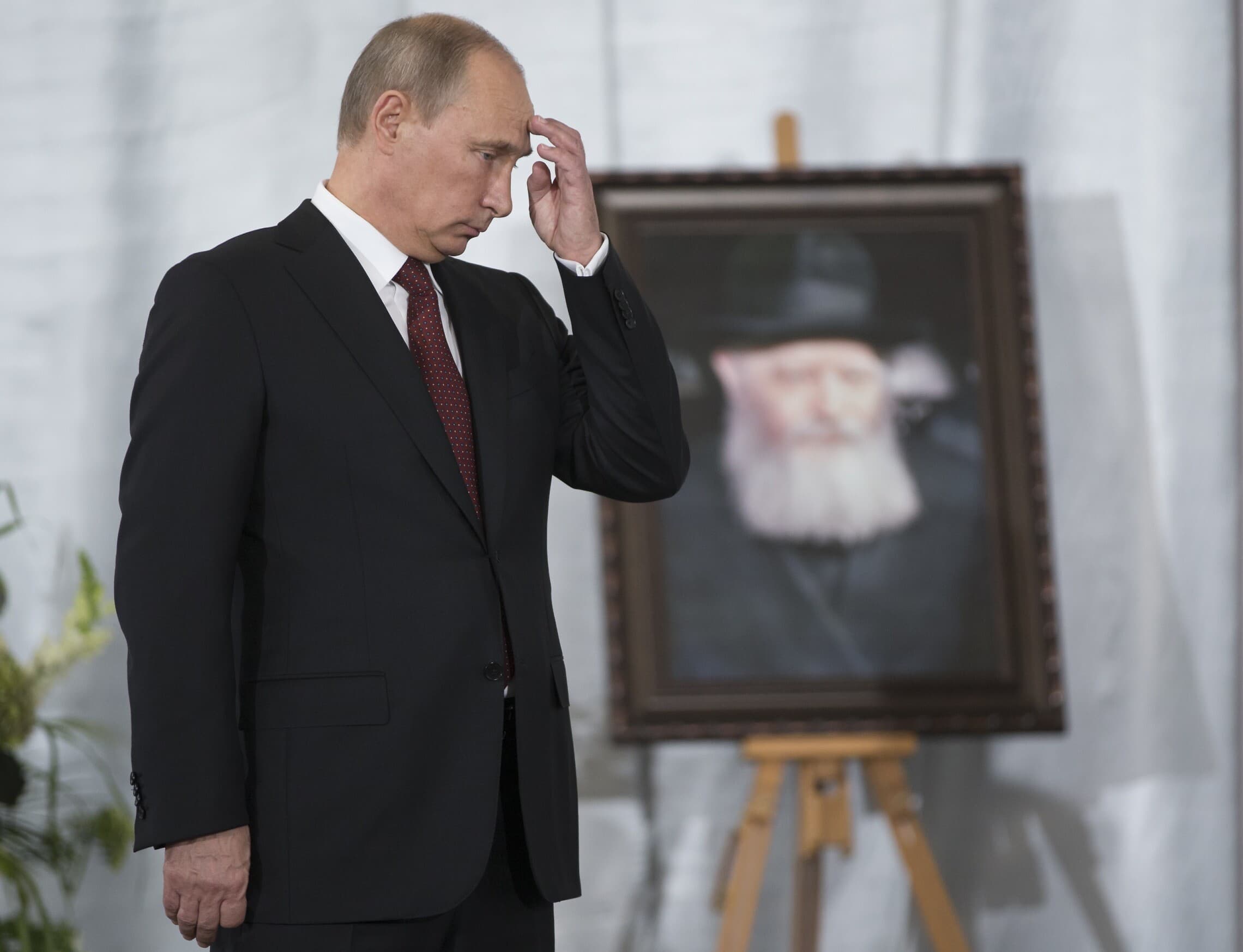 נשיא רוסיה ולדימיר פוטין במוזיאון היהדות והסובלנות של מוסקבה מול תמונתו של האדמו&quot;ר האחרון של חב&quot;ד רבי מנחם מנדל שניאורסון, 13 ביוני 2013 (צילום: AP Photo/Alexander Zemlianichenko)