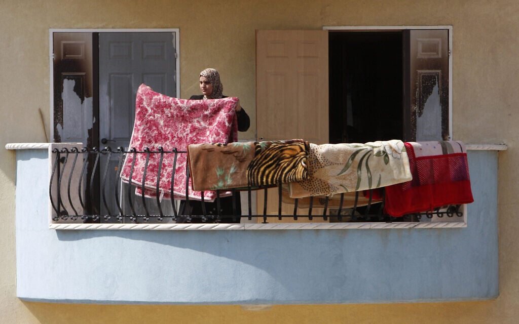 תושבת אום אל-פחם תולה כביסה במרפסת ביתה, אילוסטרציה (צילום: מרים אלסטר/פלאש90)