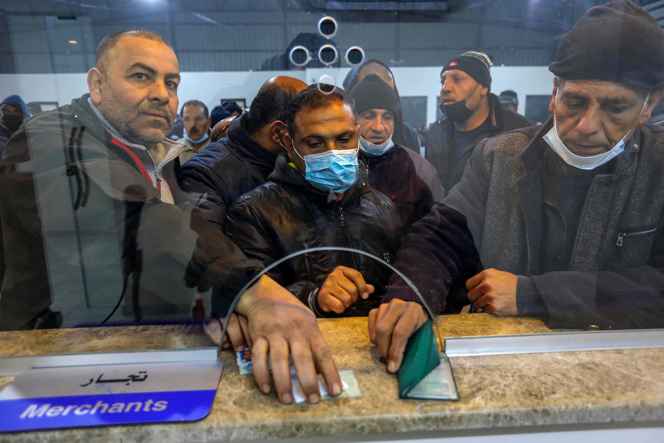 עובדים פלסטינים מעזה מציגים אישורי עבודה במעבר ארז, 13 במרץ 2022