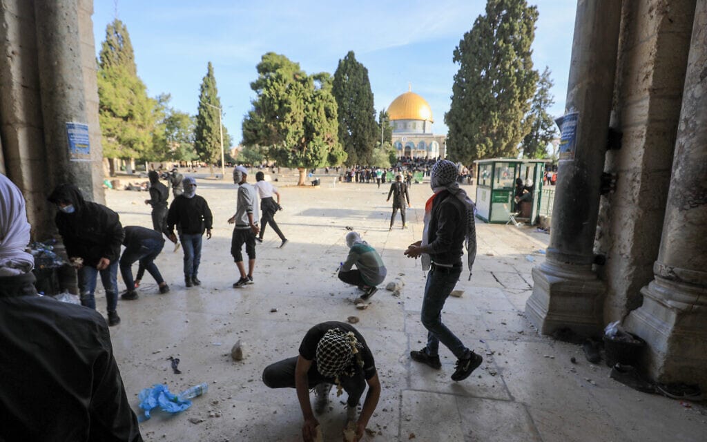 מפגינים פלסטינים זורקים אבנים בהר הבית במהלך תפילות שישי של הרמדאן במסגד אל אקצא, 22 באפריל 2022 (צילום: Jamal Awad/Flash90)