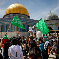 מפגינים פלסטינים מניפים דגלי חמאס ברחבת מסגד אל אקצא במהלך תפילות שישי בחג הרמדאן, 22 באפריל 2022 (צילום: Jamal Awad/Flash90)