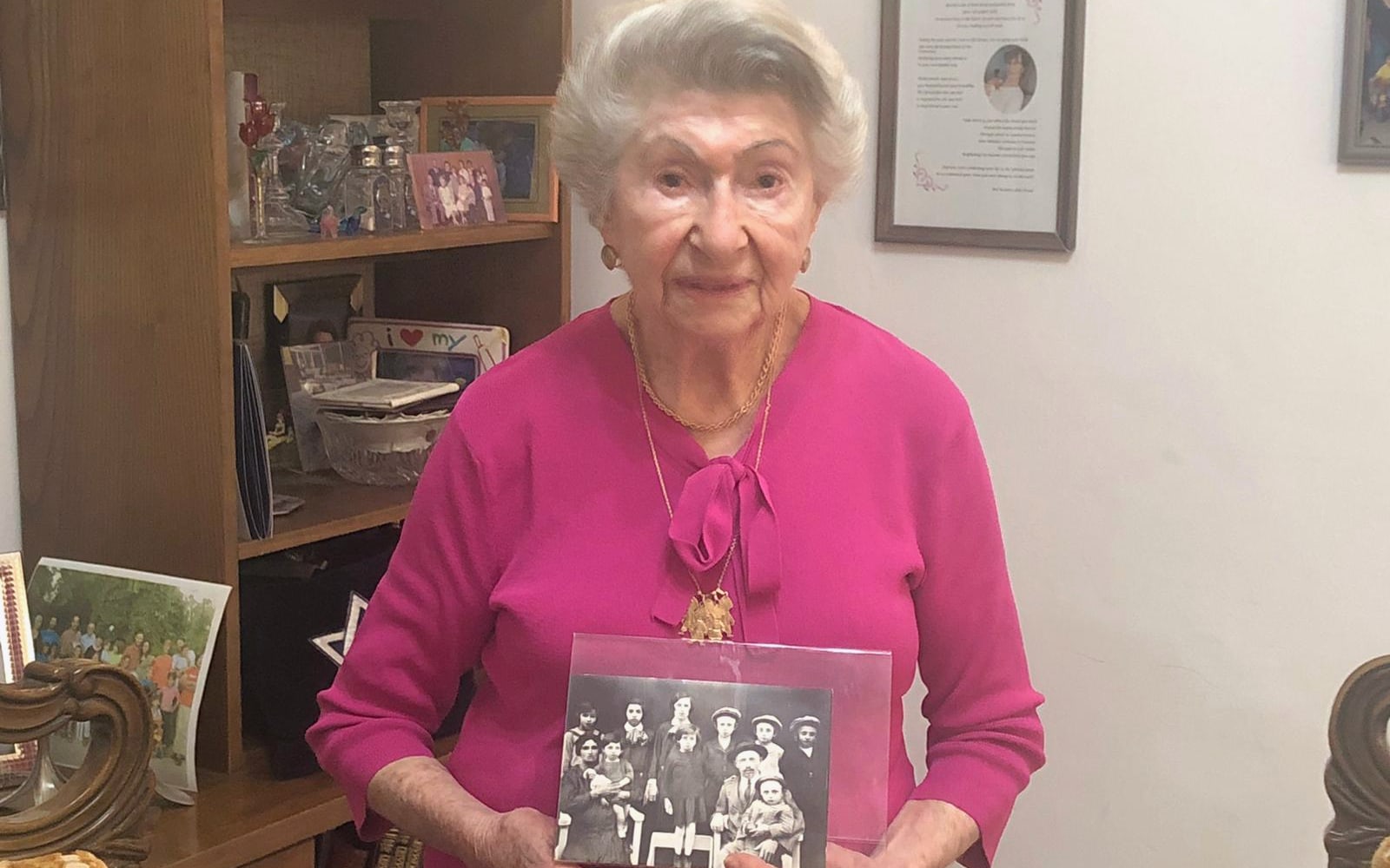 אולגה ציק קיי מחזיקה תמונה של משפחתה באויפהרטו, הונגריה, מלפני מלחמת העולם השנייה, בביתה בשערי תקווה, 17 באפריל 2022 (צילום: רנה גרט-זנד)