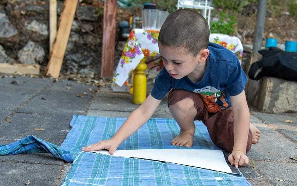 ילד מכין דגלון בד לכבוד יום העצמאות בקריית טבעון, אפריל 2022 (צילום: יסמין להב)