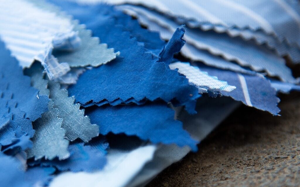 בדים בצבעי כחול לבן ותכלת לצורך הכנת דגלוני בד לכבוד יום העצמאות בקריית טבעון, אפריל 2022 (צילום: יסמין להב)