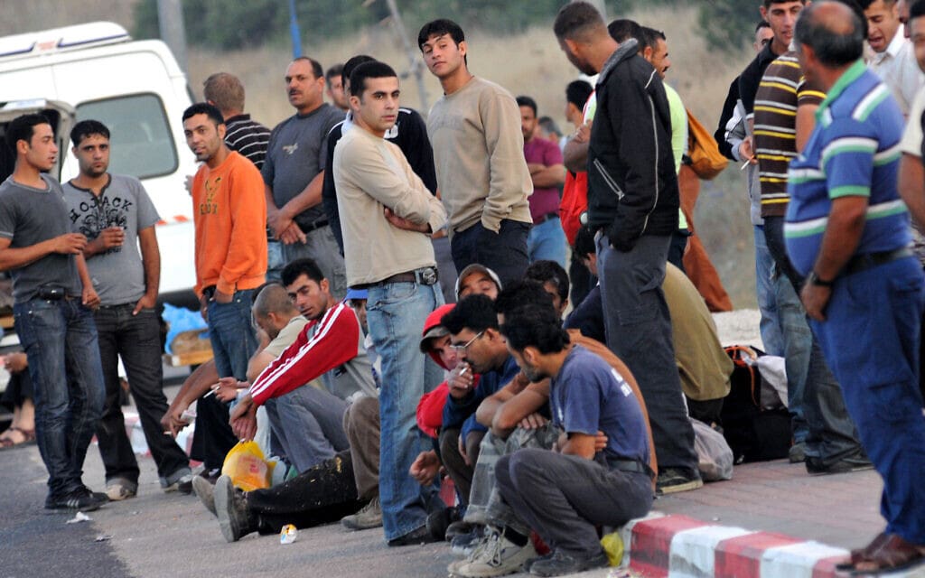 פועלים פלסטינים מהגדה המערבית המועסקים בישראל מחכים לאנשי הקשר שלהם אחרי שחצו את מחסום מכבים בכביש 443, יולי 2009 (צילום: ג&#039;ורג&#039; נובומינסקי/ פלאש90)