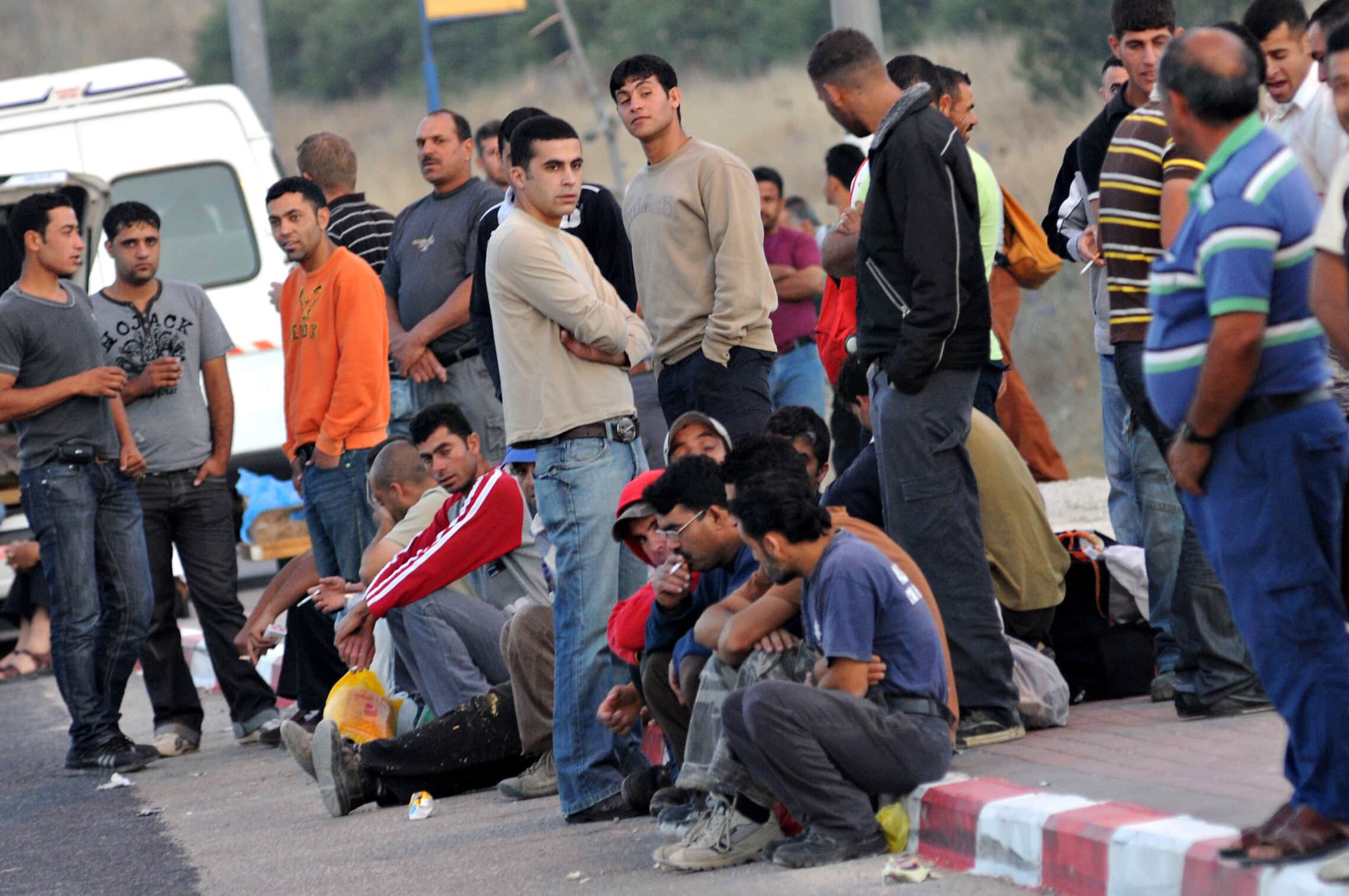 פועלים פלסטינים מהגדה המערבית המועסקים בישראל מחכים לאנשי הקשר שלהם אחרי שחצו את מחסום מכבים בכביש 443, יולי 2009 (צילום: ג&#039;ורג&#039; נובומינסקי/ פלאש90)