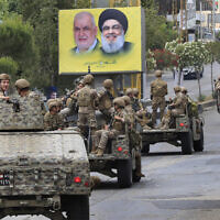 פטרול צבאי בדרום לבנון על רקע כרזות בחירות של חזבאללה, 15 במאי 2022 (צילום: AP Photo/Mohammed Zaatari)