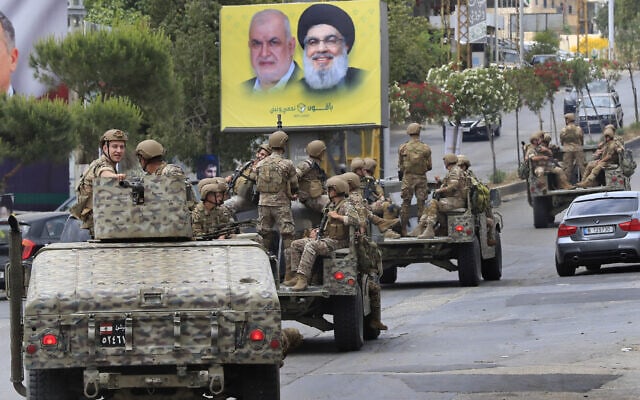 פטרול צבאי בדרום לבנון על רקע כרזות בחירות של חזבאללה (צילום: AP Photo/Mohammed Zaatari)