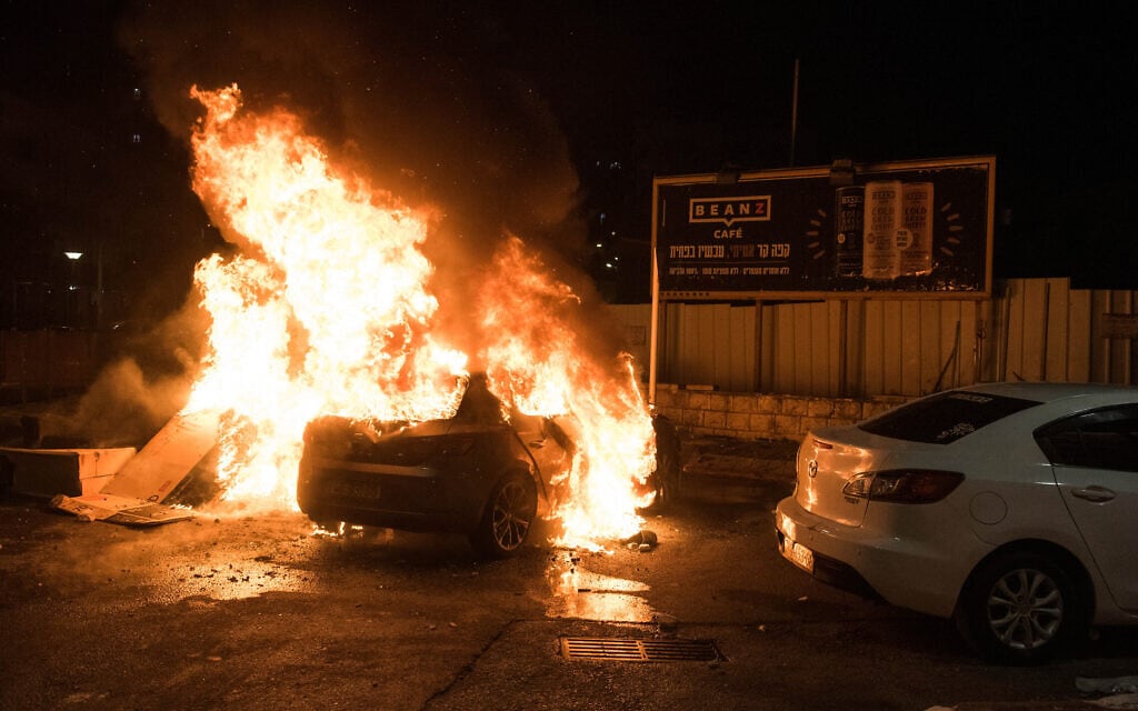 מכונית עולה באש בזמן המהומות בין ערבים ליהודים בעכו, 12 במאי 2021 (צילום: Roni Ofer/Flash90)