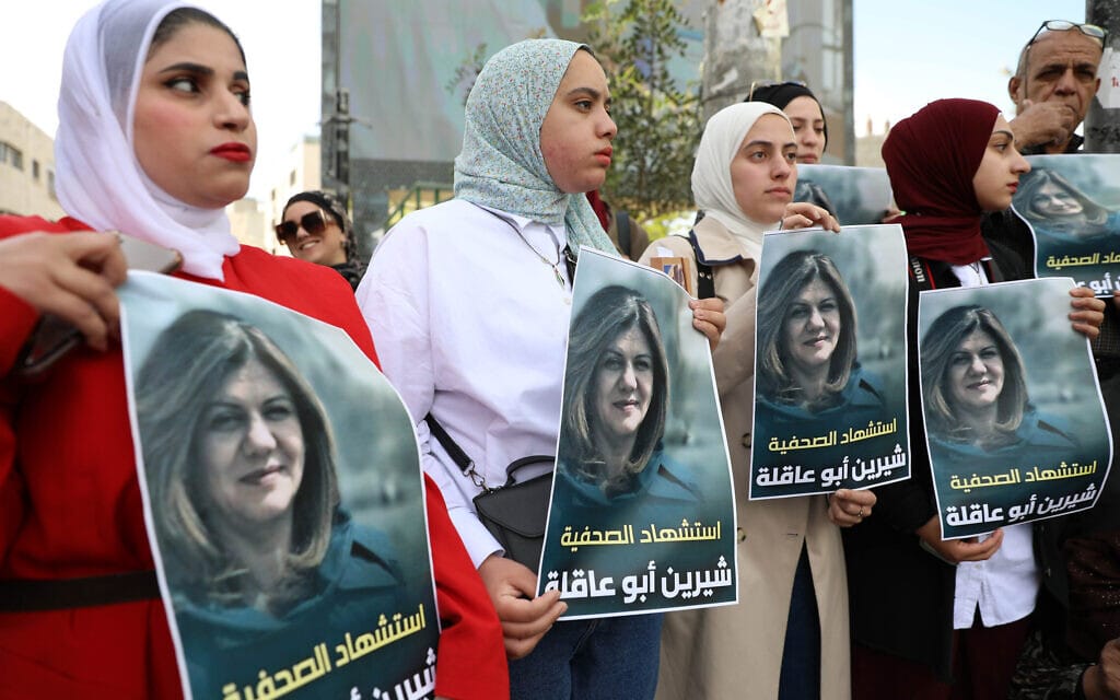 נשים פלסטיניות בחברון מחזיקות בתמונה של העיתונאית שירין אבו עאקלה, שנורתה למוות בג&#039;נין. 11 במאי 2022 (צילום: Wisam Hashlamoun/Flash90)