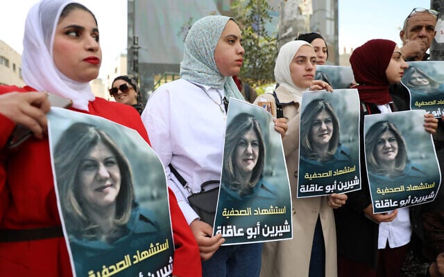 נשים פלסטיניות בחברון מחזיקות בתמונה של העיתונאית שירין אבו עאקלה, שנורתה למוות בג'נין. 11 במאי 2022 (צילום: Wisam Hashlamoun/Flash90)