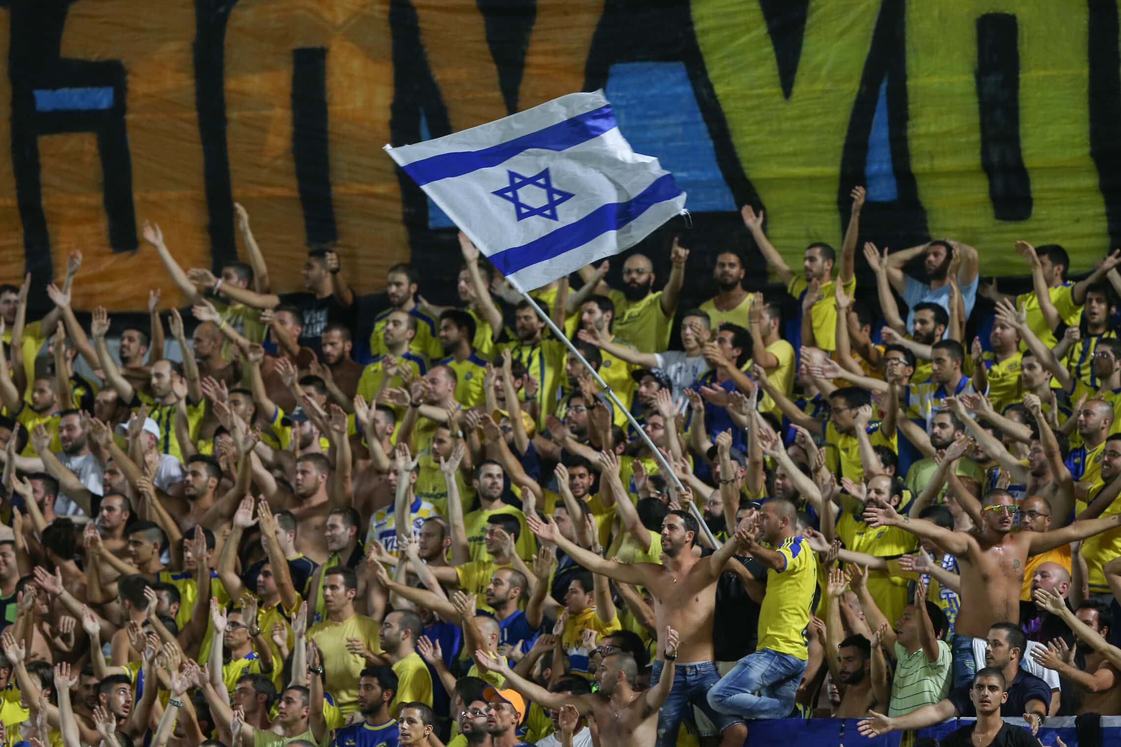 אוהדי מכבי ת&quot;א מניפים את דגל ישראל באיצטדיון בלומפילד בסיבוב הצ&#039;מפיונס ליג מול שווייץ, 25 באוגוסט 2015 (צילום: יונתן זינדל/פלאש90)