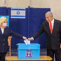 ראש הממשלה בנימין נתניהו ורעייתו שרה מצביעים בקלפי בבחירות לכנסת, 23 במרץ 2021 (צילום: Marc Israel Sellem/POOL)