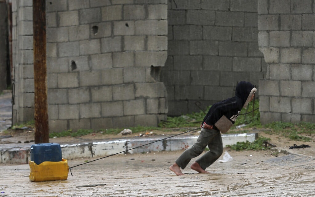 ילד פלסטיני מעזה גורר מכל פלסטיק מלא במים לבית משפחתו, 24 בינואר 2022 (צילום: AP Photo/Adel Hana)