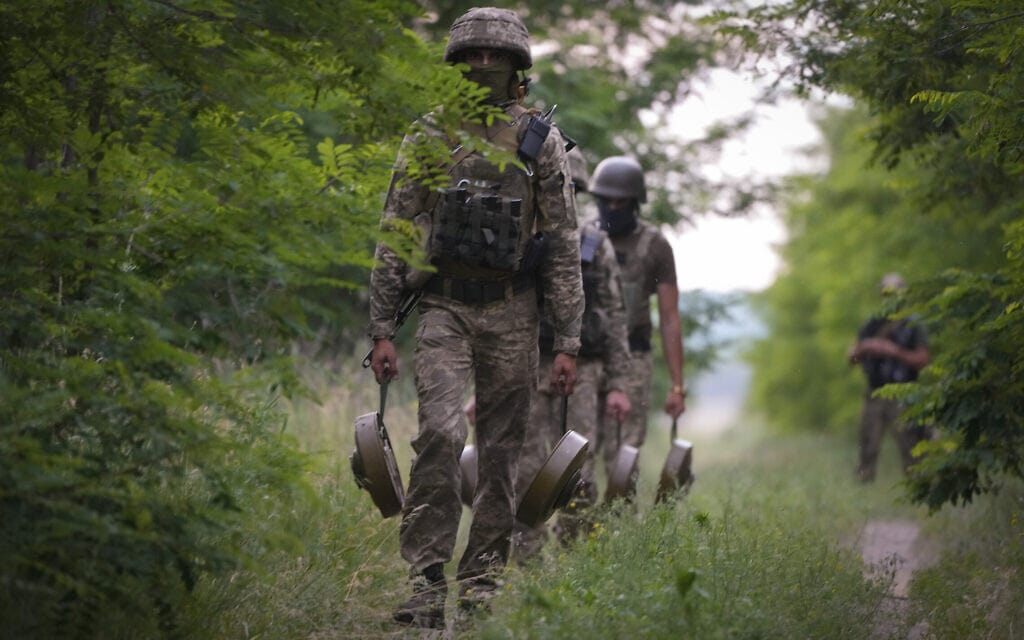 חיילי הכוחות המיוחדים של צבא אוקראינה מתקינים מוקשים נגד טנקים בדרכי הצבא הרוסי לתוך המדינה, ביער במחוז דונייסק, 14 ביוני 2022 (צילום: AP Photo/Efrem Lukatsky)