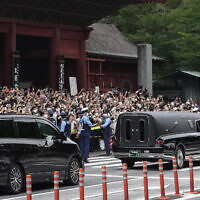 המונים בטוקיו ליד הרכב הנושא את ארונו של ראש הממשלה לשעבר של יפן, שינזו אבה, 12 ביולי 2022 (צילום: Hiro Komae, AP)