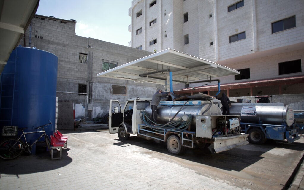 גבר פלסטיני ממלא מכלים במים כדי למכור אותם בתחנת מי שתייה בעזה, 14 באפריל 2016 (צילום: AP Photo/Khalil Hamra)