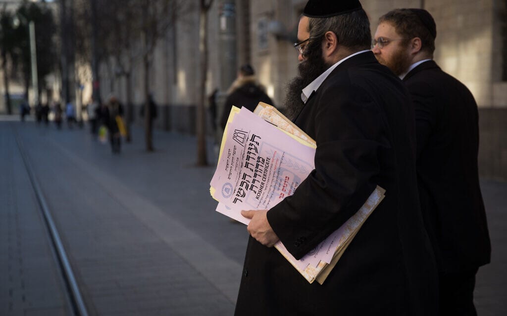 נציגים של הרבנות הראשית חוצים את רחוב יפו בירושלים בדרכם למסור תעודת כשרות, 31 בדצמבר 2019 (צילום: הדס פרוש, פלאש 90)