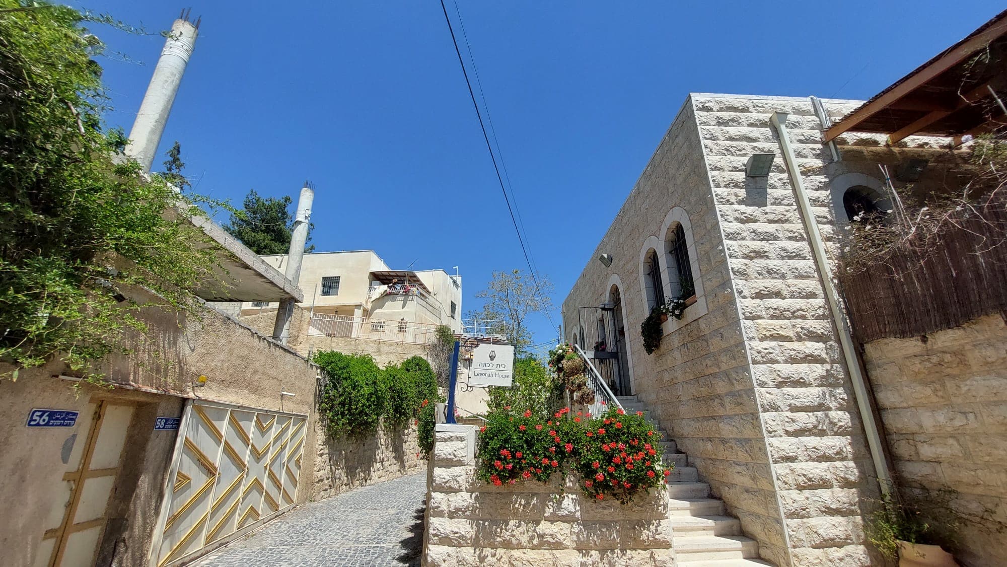 בית פלסטיני שבנייתו נעצרה מימין, ובית יהודי שעבר שיפוץ והרחבה משמאל, בוואיד רבבה שגובלת בגיא בן הינום. אפריל 2022 (צילום: עומר שרביט)