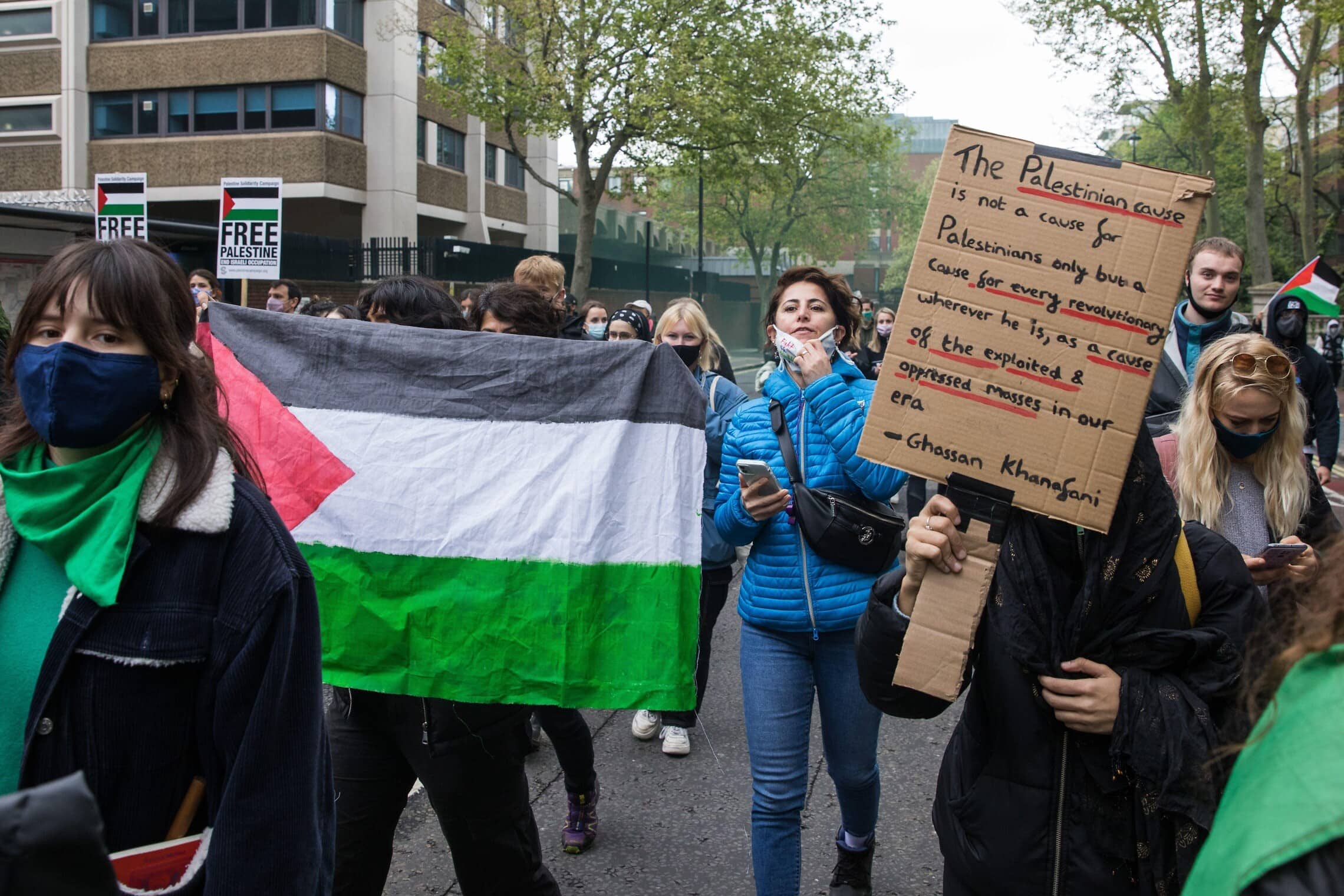 מפגינים מול שגרירות ישראל בלונדון במהלך מבצע &quot;שומר החומות&quot; נושאים שלט עם ציטוט מכתביו של ע&#039;סאן כנפאני, 15 במאי 2021 (צילום: Mark Kerrison/Alamy Live News)