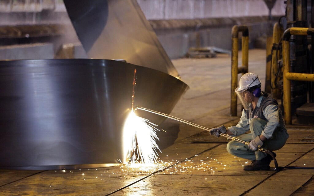 פועל במפעל פלדה של חברת Mobarakeh Steel האיראנית, דרומית לעיר טהרן (צילום: AP Photo/Vahid Salemi)