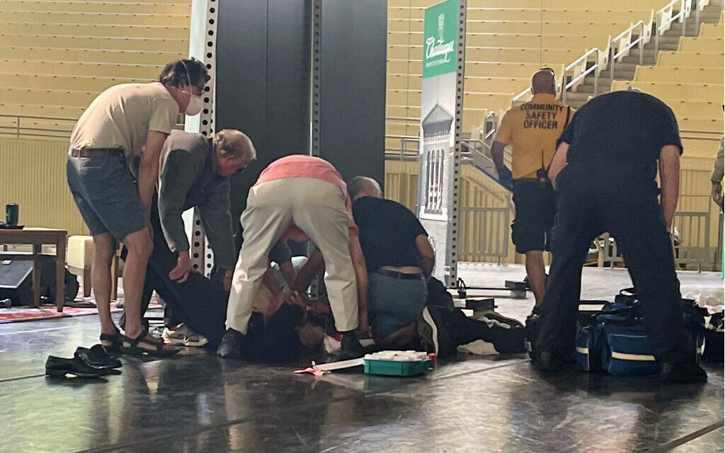 סלמאן רושדי מוטל על הקרקע, סביבו אנשים המגישים לו סיוע, לאחר שהותקף במכון צ'וטקווה שבניו יורק, 12 באוגוסט 2022 (צילום: Joshua Goodman, AP)