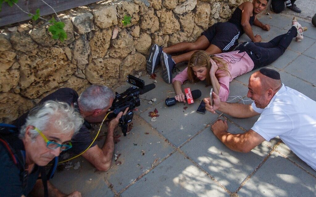 אנשי תקשורת תופסים מחסה בזמן אזעקה באשקלון, 20 במאי 2021 (צילום: Edi Israel/Flash90) אנשי תקשורת תופסים מחסה בזמן אזעקה באשקלון, 20 במאי 2021 (צילום: Edi Israel/Flash90)