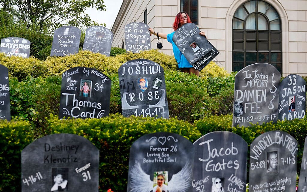 מייצג עם שמות הקורבנות שמתו ממנת יתר של אופיואידים הוצב מחוץ לבית המשפט שדן בפשיטת הרגל של "פרדו פארמה", ניו יורק, 9 באוגוסט 2021 (צילום: AP Photo/Seth Wenig)