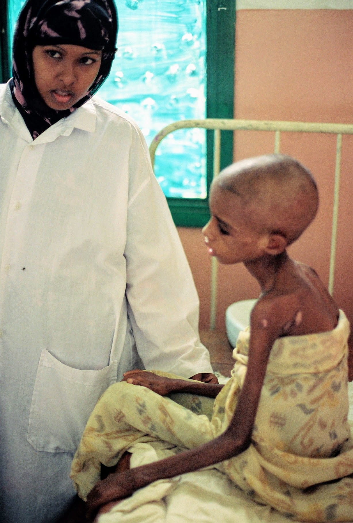 האחות במרפאה במוגדישו ואחד הילדים המטופלים (צילום: חנני רפופורט)