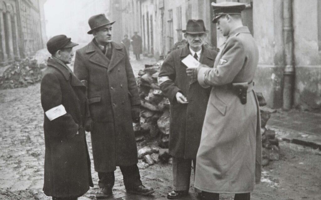 שוטר גרמני בודק את תעודות של יהודים בקרקוב, פולין, 1941 (צילום: הארכיון הלאומי של קרקוב Via JTA)