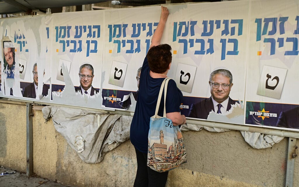 עוברי אורח תולשים שלטים של איתמר בן-גביר בתל אביב, 19 בספטמבר 2022 (צילום: אבשלום ששוני/פלאש90)